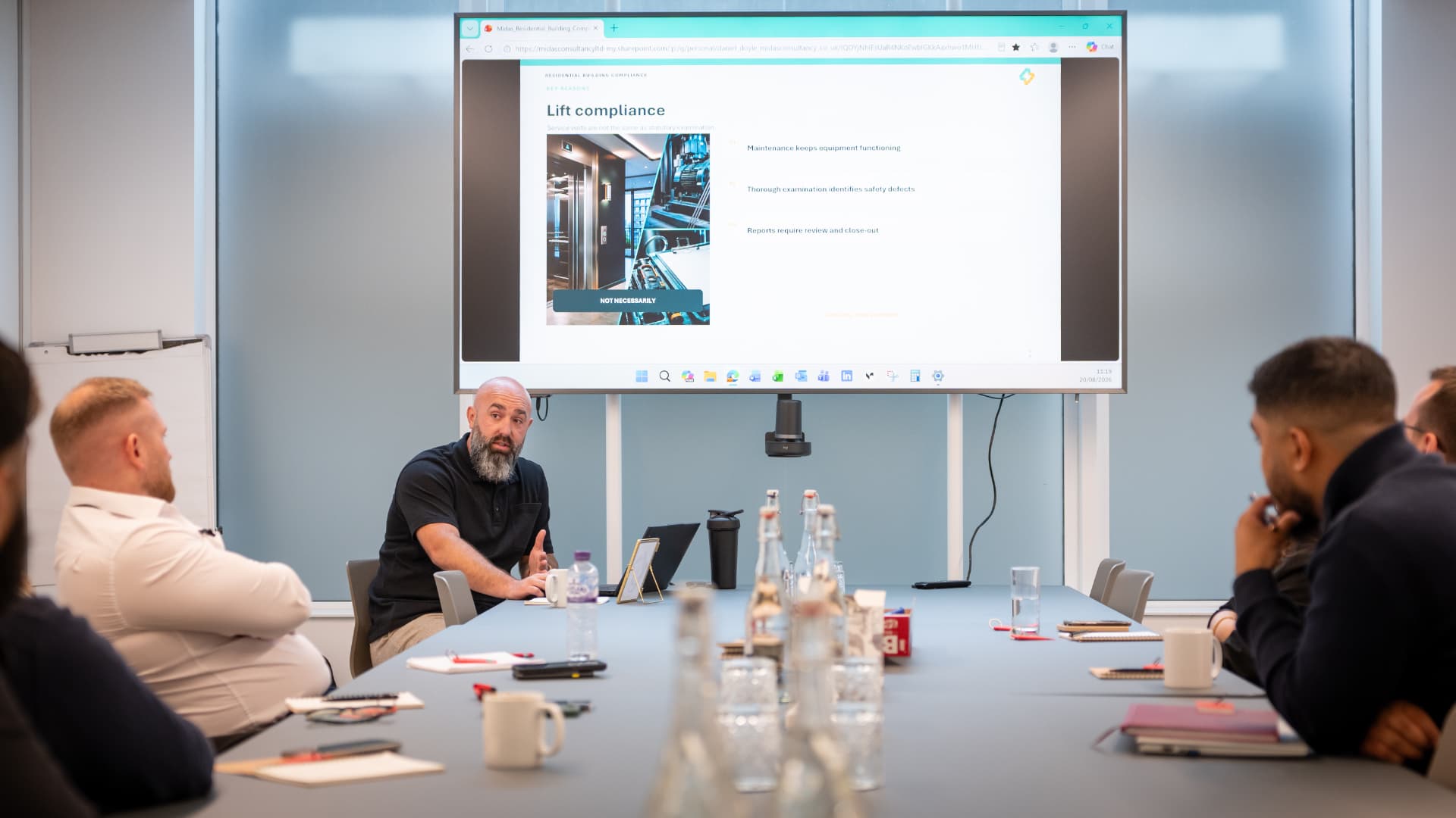 Project MEP team discussing lift compliance at a client briefing